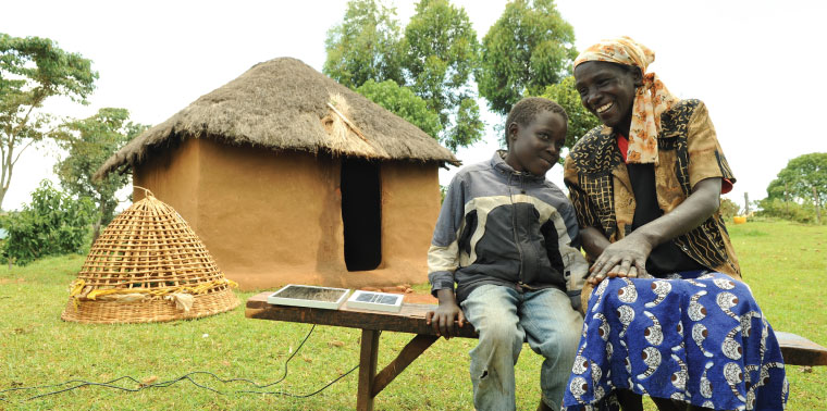 A mother and son charge their solar lanterns in the Kenyan sun